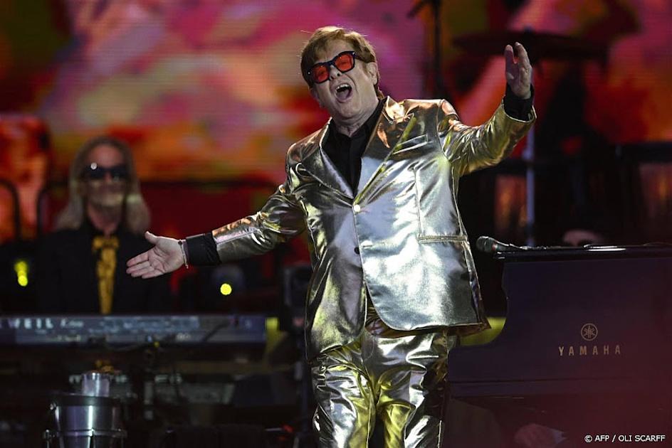 Elton John in gouden pak op podium tijdens concert