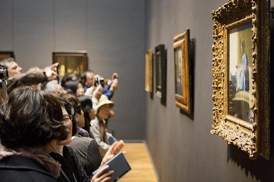 Deel je Museumkaart tijdens de Museumweek / Foto; "Museumbezoekers in een kabinet van de Eregalerij met schilderijen van Johannes Vermeer" door René den Engelsman / Rijksmuseum