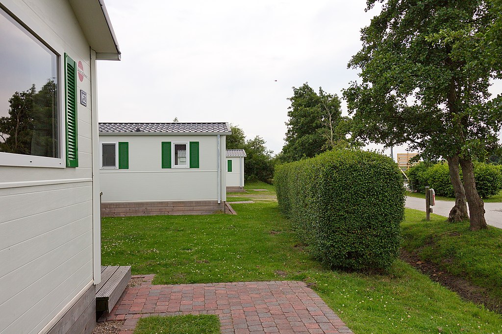 Het Rijk bepaalt of er permanent gewoond mag worden op vakantieparken / Foto: "Deich vor Upleward (Krummhörn), Niedersachsen, Deutschland" door Losch