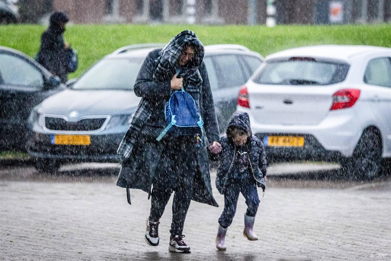 moeder met kind tijdens heftige regenval