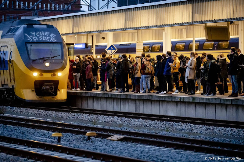 Spoor met trein en veel mensen die wachten