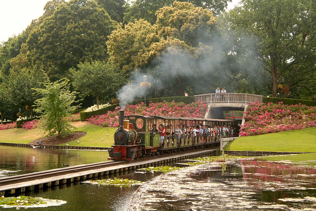 Erfgoedverenigingen niet blij met elektrificeren Stoomtrein in Efteling / Foto: "Locomotief 'Aagje' van de Efteling Stoomtrein Maatschappij met trein rijdt over de brug in de Grote Vijver" door Erik Swierstra