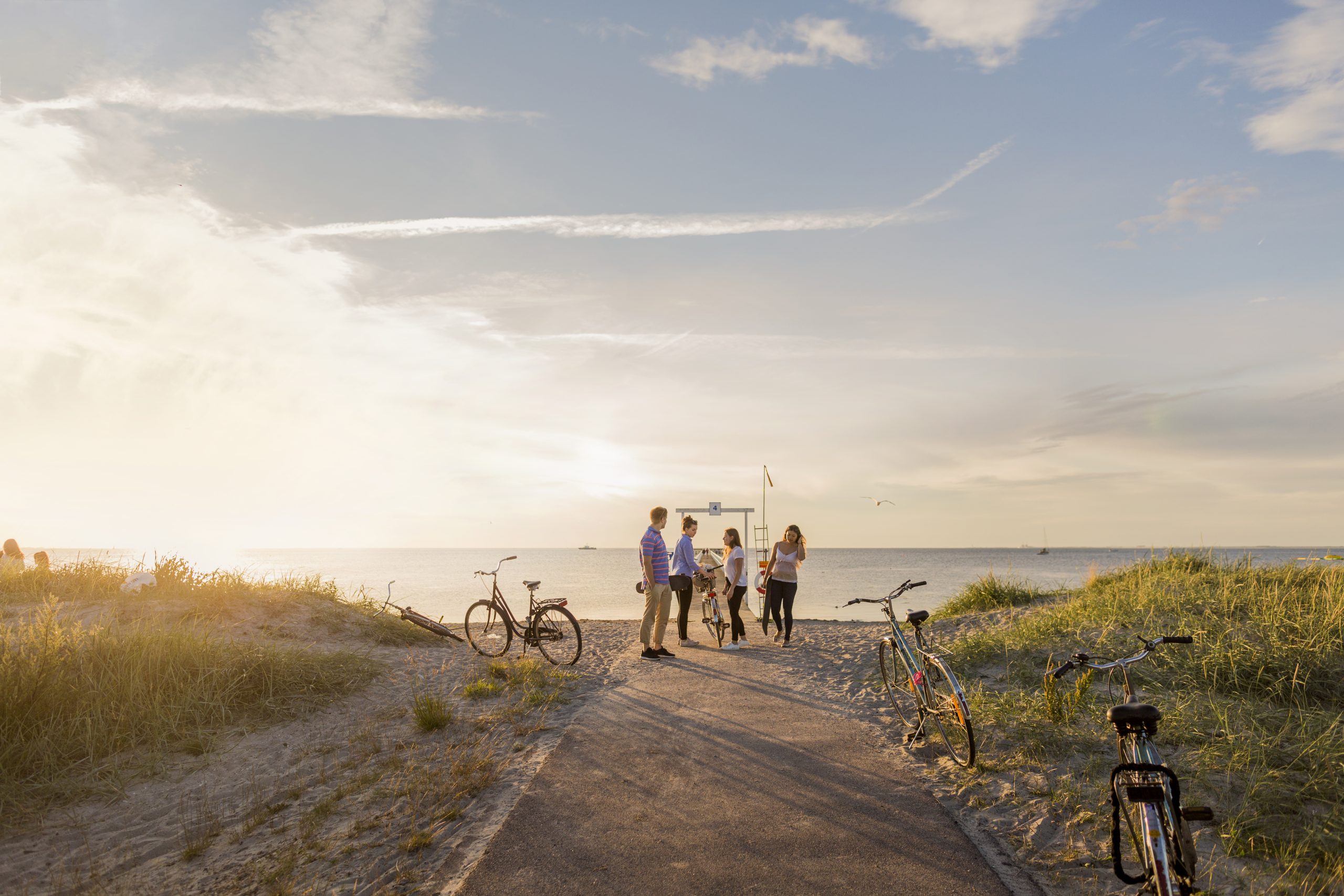 mensen staan bij duin strand