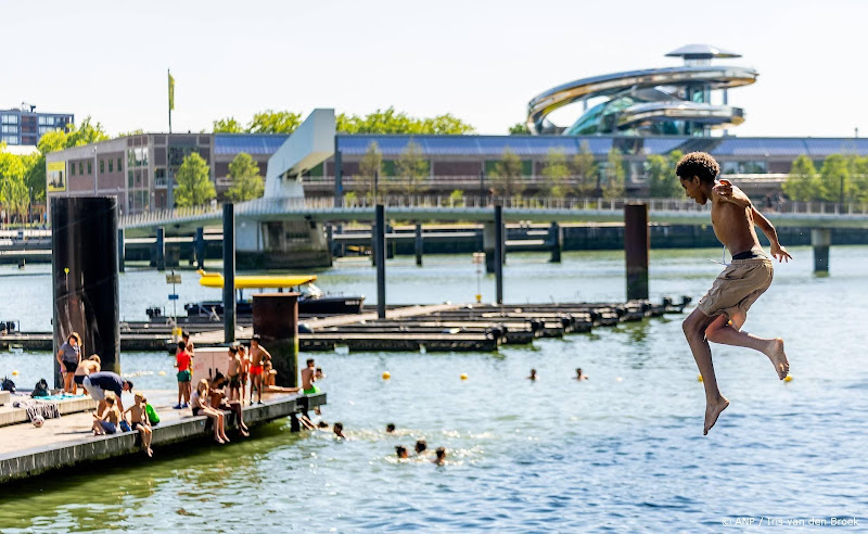 mensen bij buitenwater en kind dat in water springt