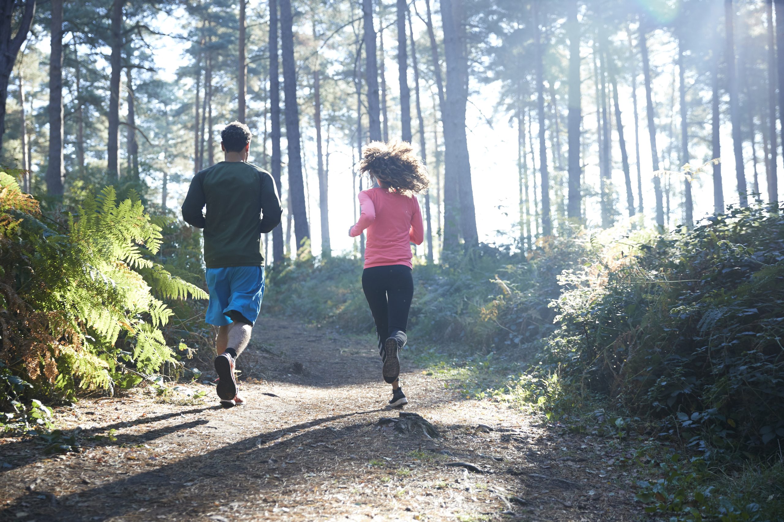 man en vrouw rennen in bos