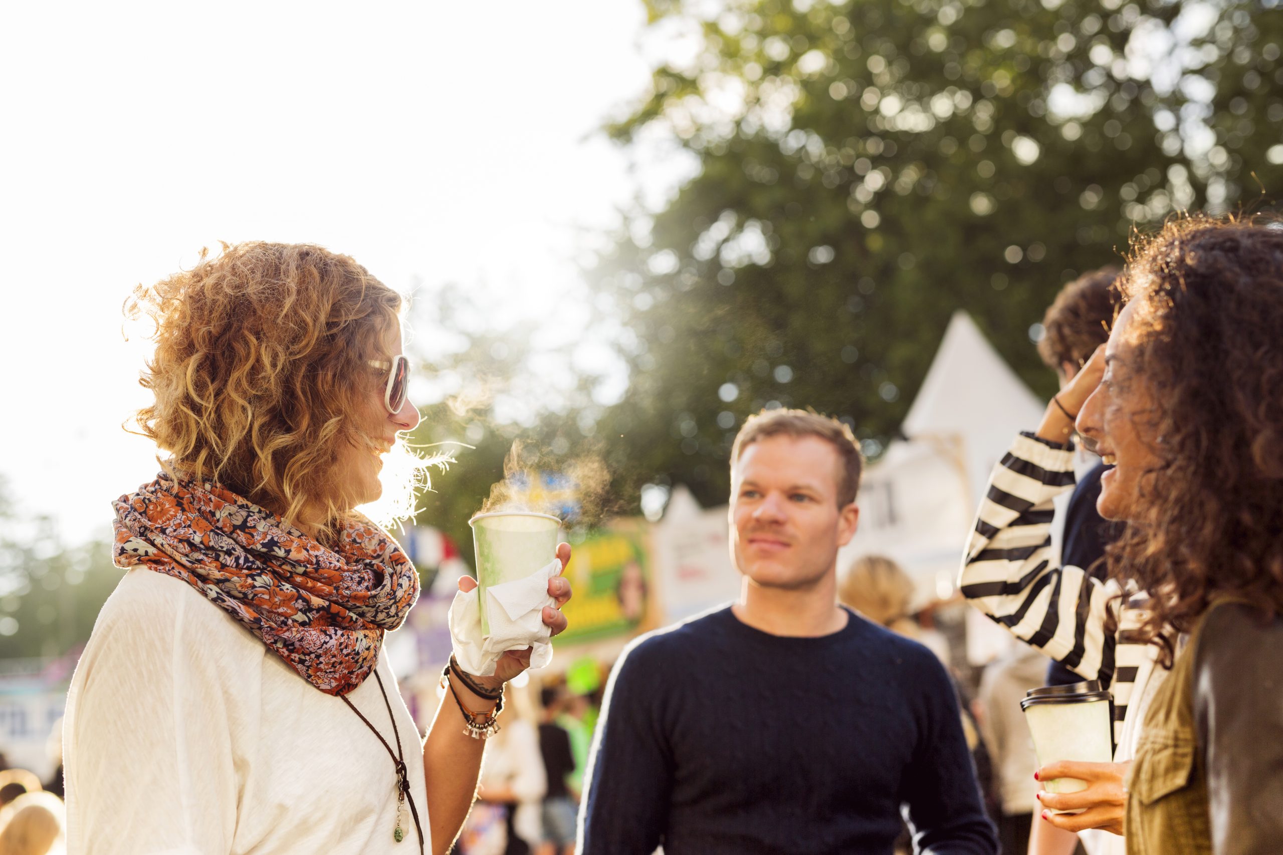 vrouw drinkt drankje tijdens festival en lacht