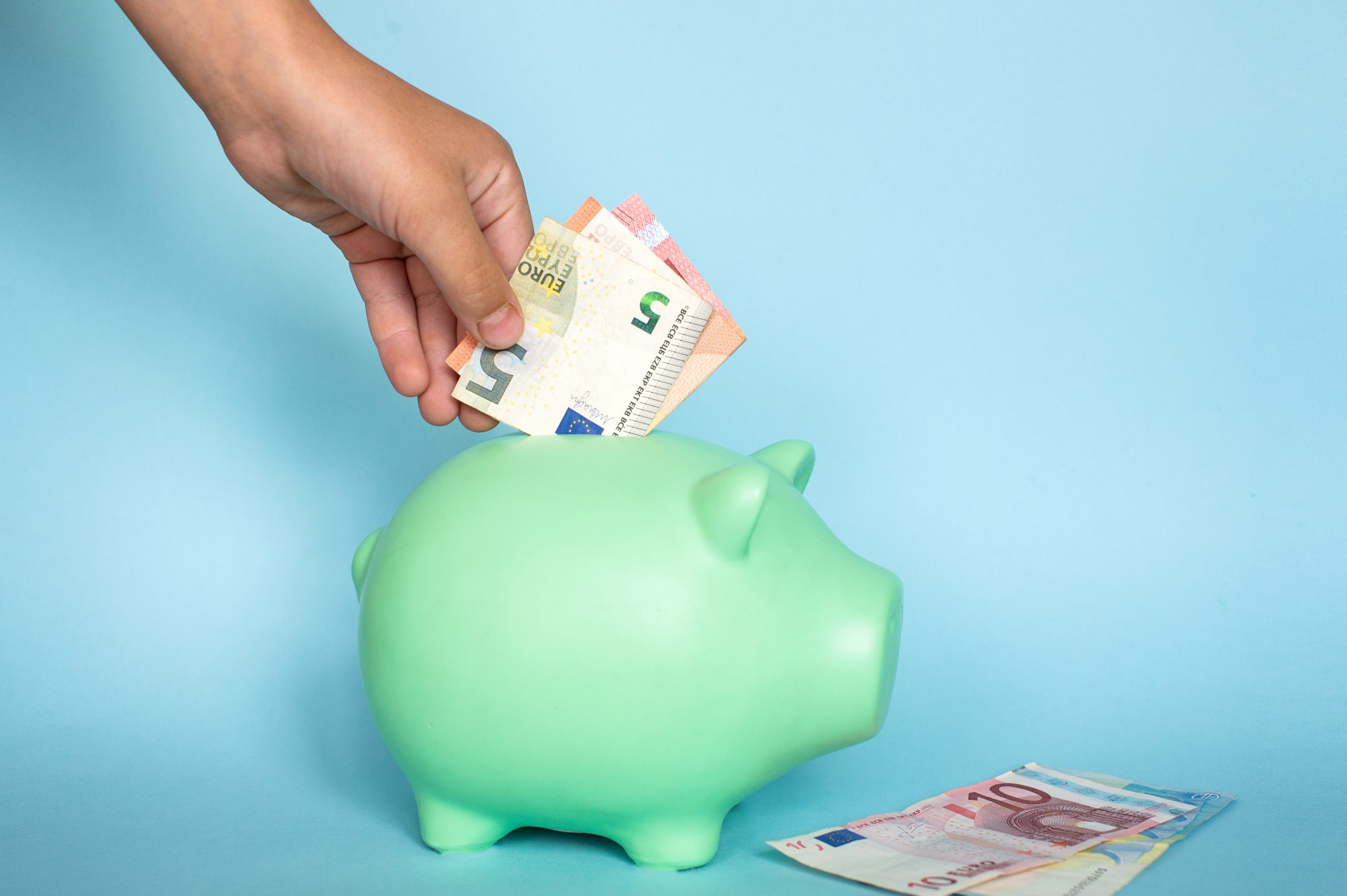 iemand stopt geld in spaarpot